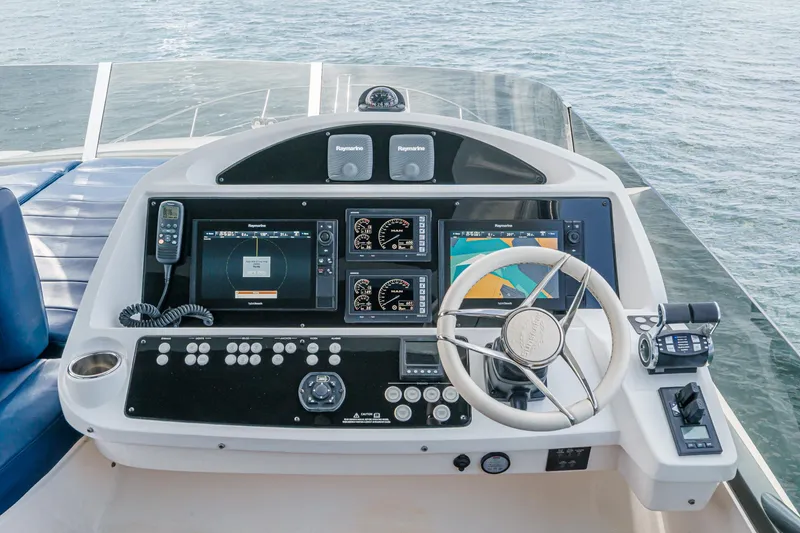 Slide: The Image of Control panel of a 2017 Sunseeker Manhattan 65 yacht with navigation screens and steering wheel. - 49