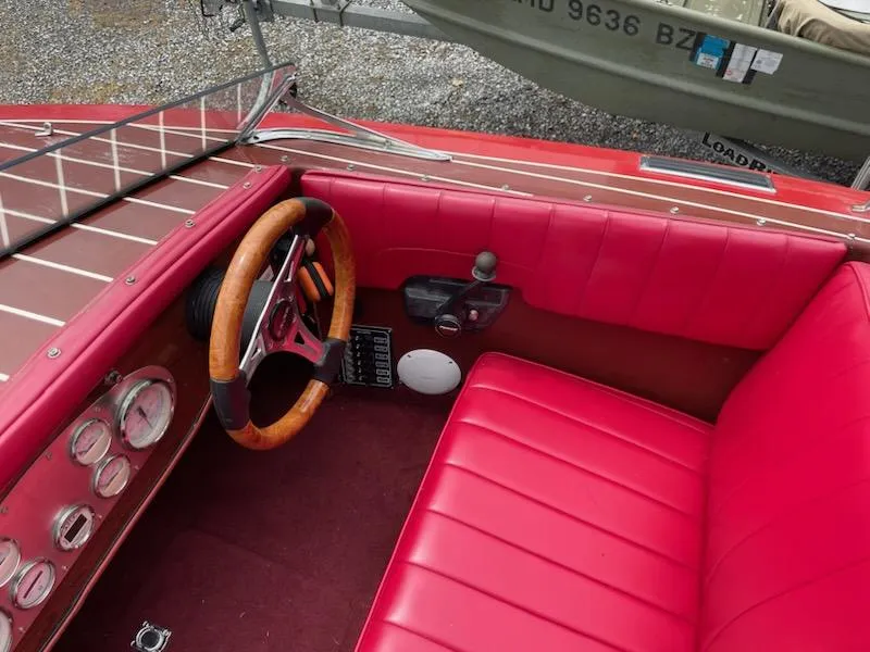 Slide: The Image of Red interior of a 2002 Alsberg Brothers 17 boat with wooden steering wheel. - 11