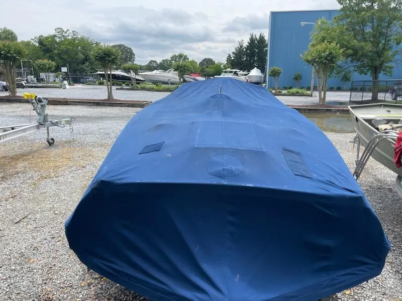 Slide: The Image of Covered Alsberg Brothers 17 boat, 2002 model, in a storage yard. - 3