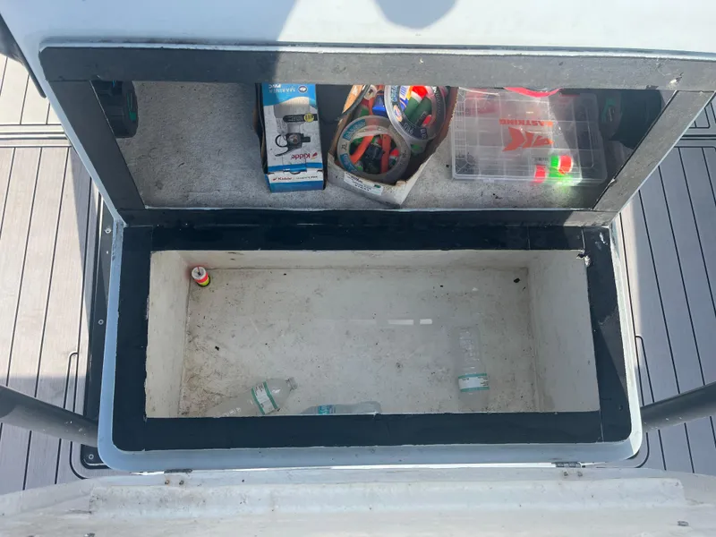 Slide: The Image of Storage compartment on a 1971 Aquasport 222 boat with fishing gear and empty bottles. - 16