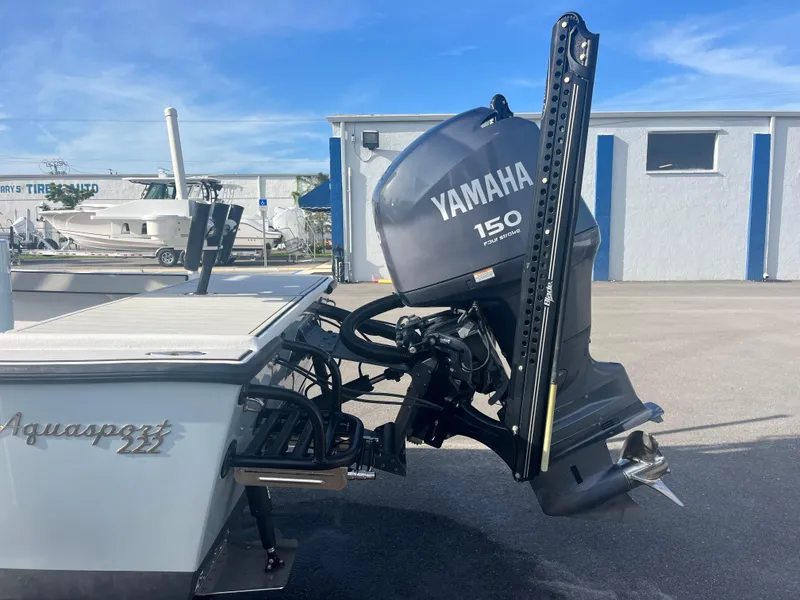 Slide: The Image of 1971 Aquasport 222 boat with Yamaha 150 outboard motor, parked outdoors. - 4