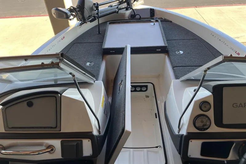 Slide: The Image of 2025 Ranger 212LS boat interior with open storage compartments and control panel. - 12