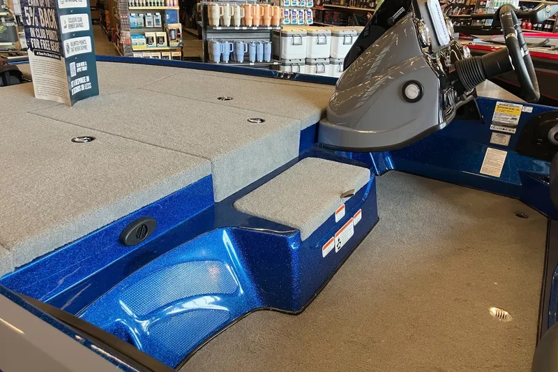 Slide: The Image of Interior of a 2025 Nitro Z17 boat with gray carpet and blue accents. - 7