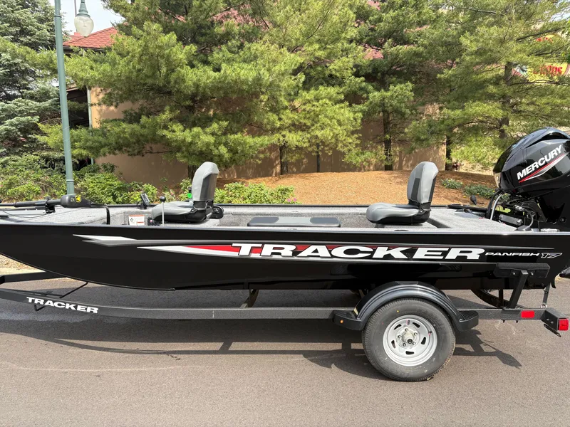 The Image of 2025 Tracker Panfish 17 boat on trailer, parked outdoors with trees in background. - 0