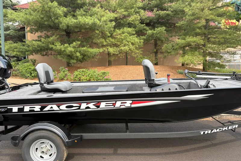 Slide: The Image of 2025 Tracker Panfish 17 boat on trailer, parked outdoors near trees. - 39