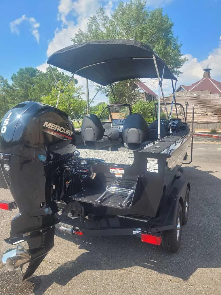 Slide: The Image of 2025 Tracker Targa V-18 WT boat with Mercury engine, parked outdoors under blue sky. - 4