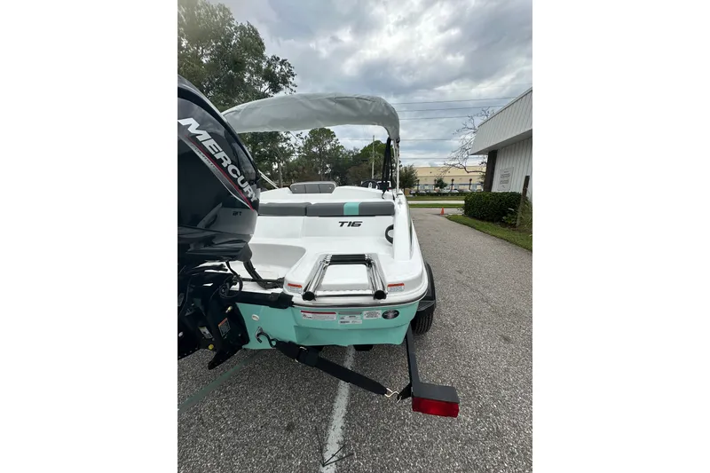Slide: The Image of 2025 Tahoe T16 boat with Mercury engine, parked outdoors on a cloudy day. - 61