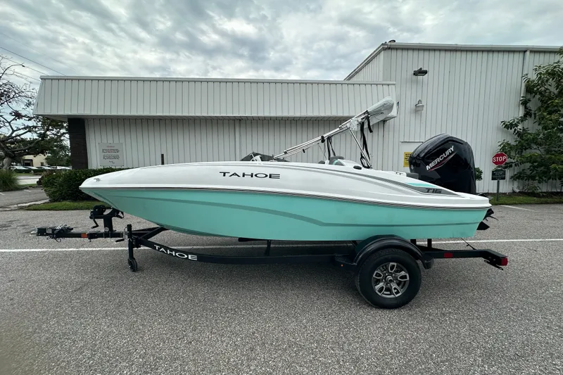 Slide: The Image of 2025 Tahoe T16 boat on trailer, parked outdoors near industrial building. - 1