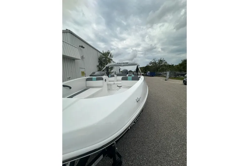 Slide: The Image of 2025 Tahoe T16 boat parked outdoors under cloudy sky. - 62
