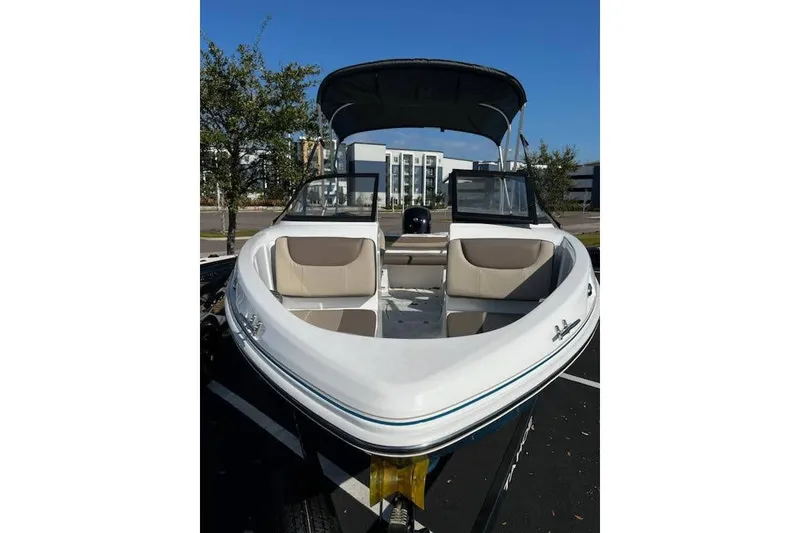 Slide: The Image of 2025 Tahoe 200 S boat with open bow seating, parked outdoors. - 1