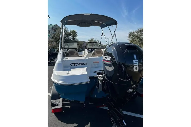 Slide: The Image of 2025 Tahoe 200 S boat with Mercury 150 engine, parked outdoors. - 2