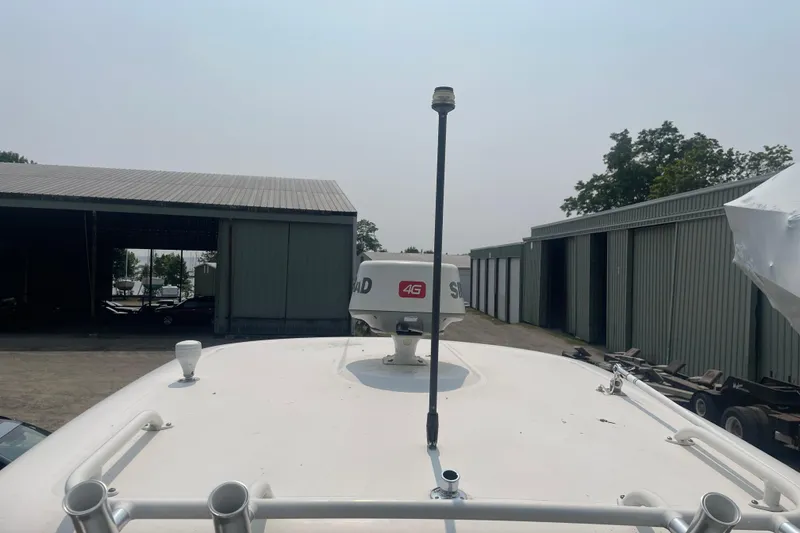 Slide: The Image of 2015 Pursuit DC 265 Dual Console boat with radar and antenna, docked near storage sheds. - 14