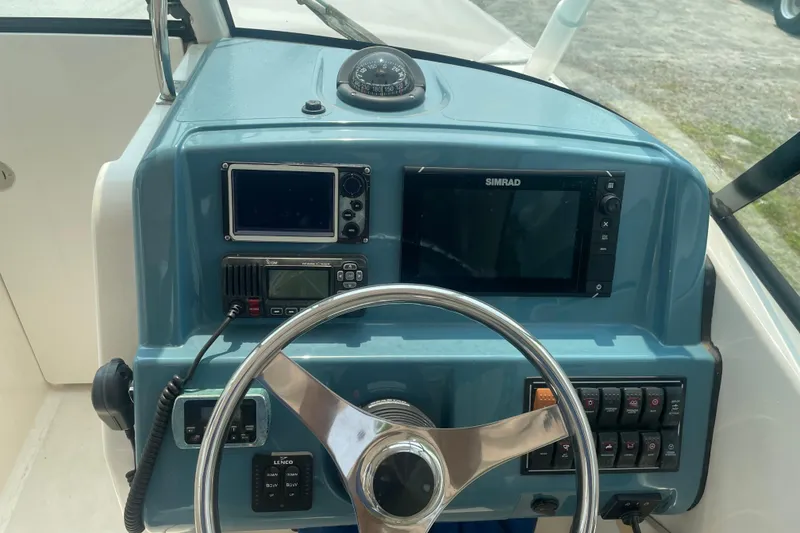 Slide: The Image of 2015 Pursuit DC 265 Dual Console boat dashboard with steering wheel and navigation equipment. - 15