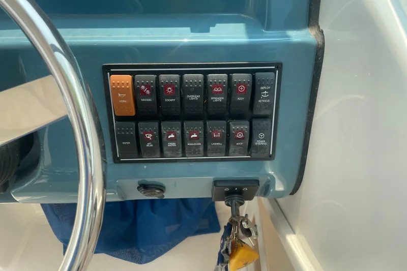 Slide: The Image of Control panel of a 2015 Pursuit DC 265 Dual Console boat with various switches. - 16