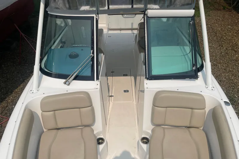 Slide: The Image of 2015 Pursuit DC 265 Dual Console boat interior with beige seating and windshield. - 17