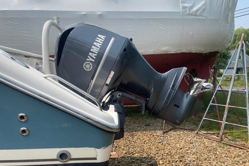 Slide: The Image of 2015 Pursuit DC 265 Dual Console with Yamaha outboard motor, docked on gravel. - 4