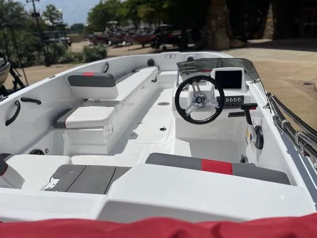 Slide: The Image of 2024 Tahoe T18 boat interior with steering wheel and seating, docked outdoors. - 3