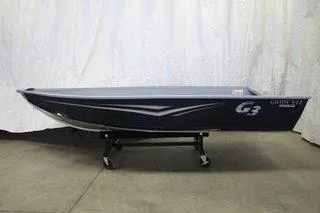 Slide: The Image of 2025 G3 Guide V12 boat on display, sleek design, dark color, indoor setting. - 3
