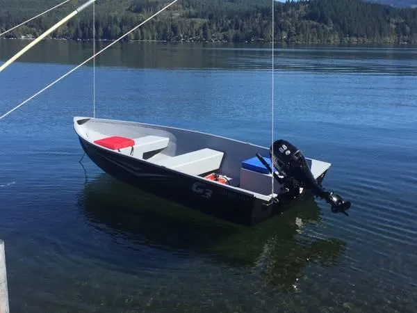 Slide: The Image of 2025 G3 Guide V12 boat on calm lake with outboard motor. - 6