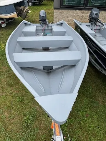 Slide: The Image of 2025 G3 Guide V12 boat on grass, featuring a sleek design and outboard motor. - 7