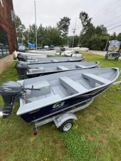 Slide: The Image of 2025 G3 Guide V12 boats on display, parked on grass with trailers. - 8