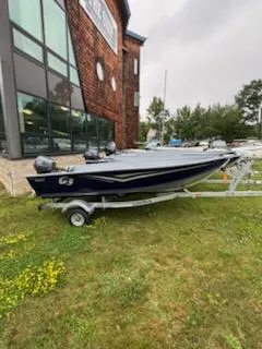 Slide: The Image of 2025 G3 Guide V12 boat on trailer outside a building, grassy area. - 9