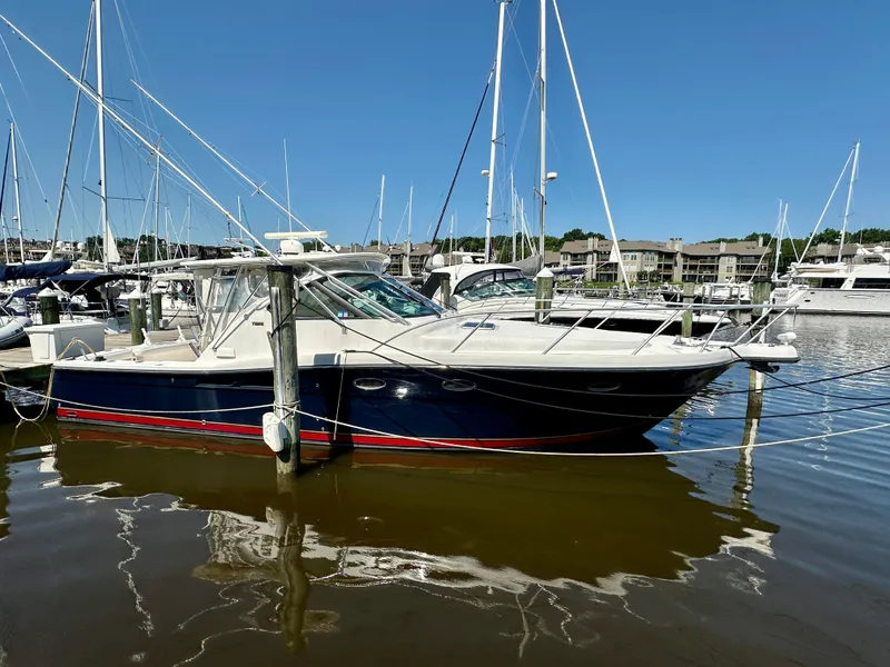 Slide: The Image of 2005 Tiara Yachts 3600 Open docked at marina, clear blue sky, calm water reflections. - 3