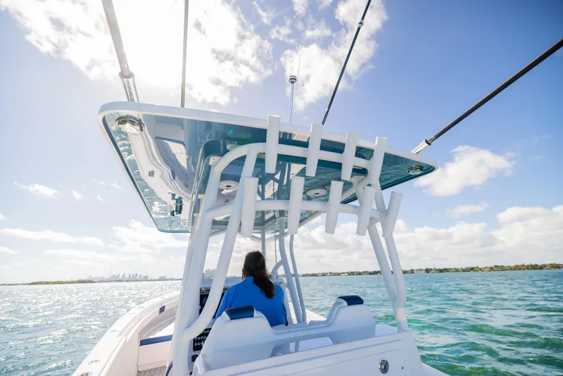 Slide: The Image of 2026 Reef Runner 340 boat cruising on open water under a clear blue sky. - 11