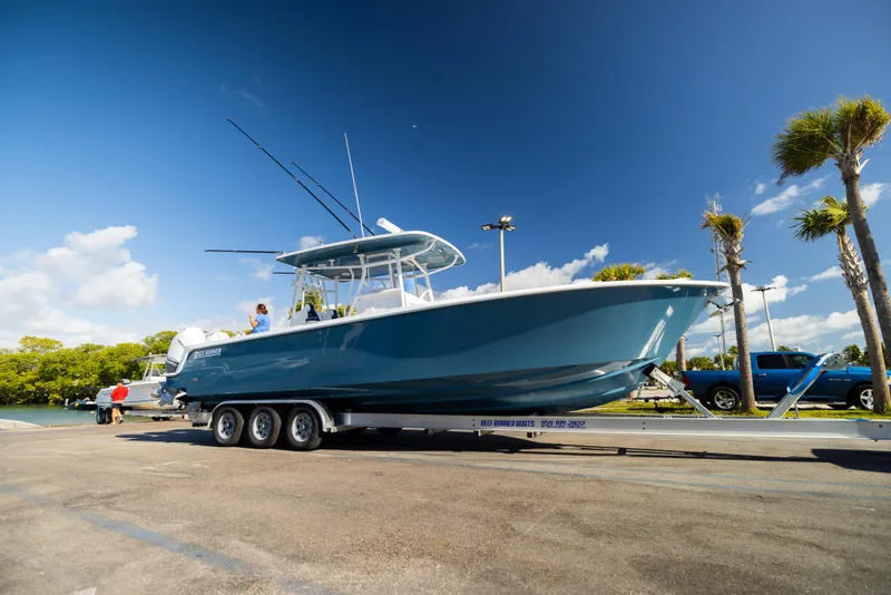 Slide: The Image of 2026 Reef Runner 340 boat on trailer under clear blue sky. - 6