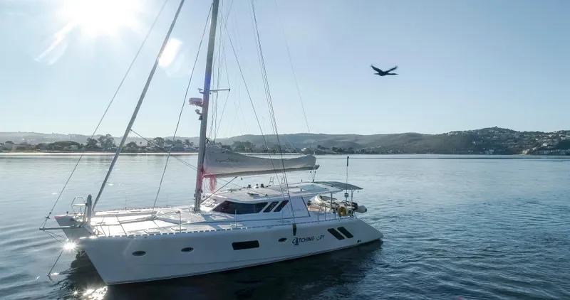 Slide: The Image of 2026 Knysna 500SE catamaran sailing on calm waters under clear sky. - 2