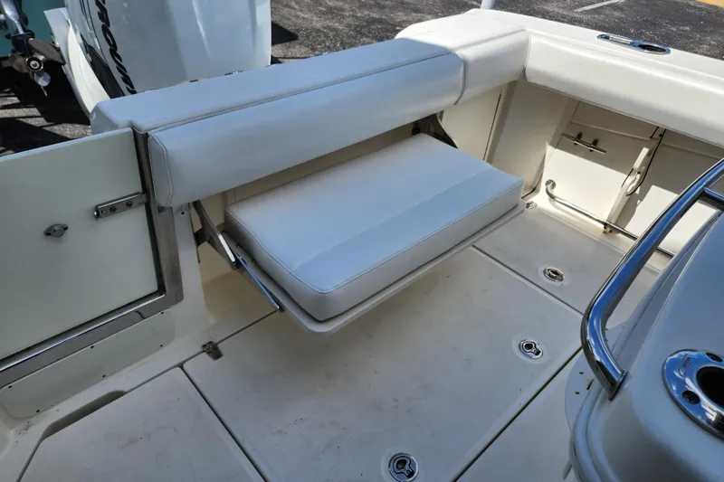 Slide: The Image of 2014 Boston Whaler 250 Outrage boat interior with foldable seating and storage compartments. - 2