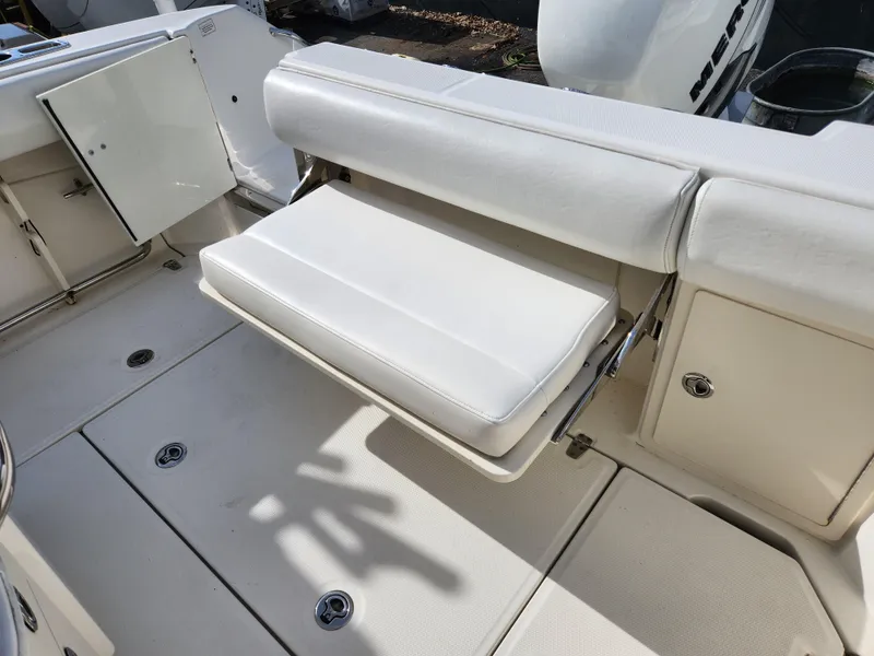 Slide: The Image of 2014 Boston Whaler 250 Outrage boat with foldable white seat and storage compartments. - 3