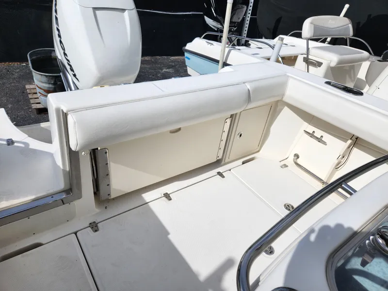 Slide: The Image of 2014 Boston Whaler 250 Outrage boat interior with white seating and storage compartments. - 4