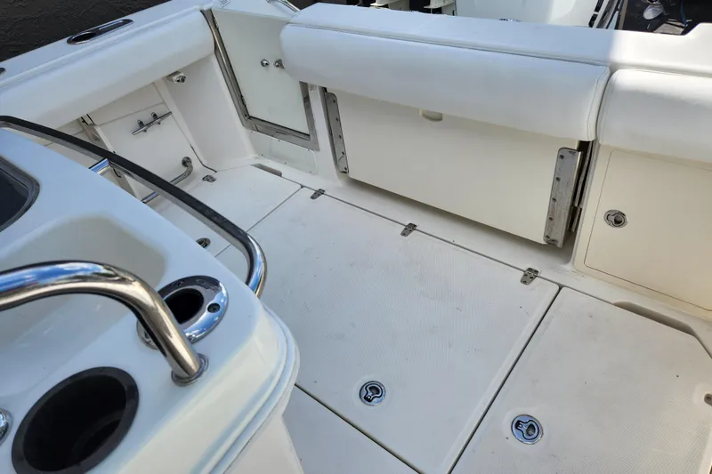 Slide: The Image of 2014 Boston Whaler 250 Outrage boat interior with white seating and storage compartments. - 5