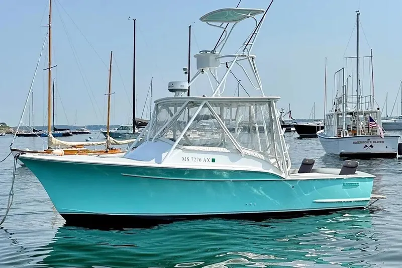 Slide: The Image of 2008 Buddy Cannady 28 Custom Express boat in a marina, turquoise hull, clear skies. - 2