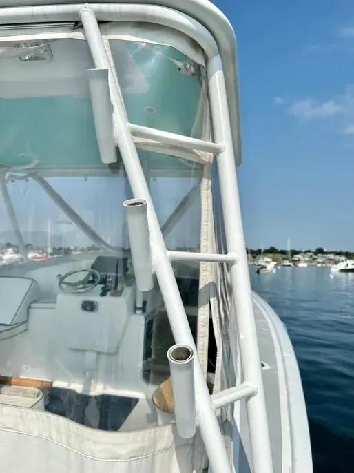 Slide: The Image of 2008 Buddy Cannady 28 Custom Express boat, featuring helm and rod holders, on calm water. - 26