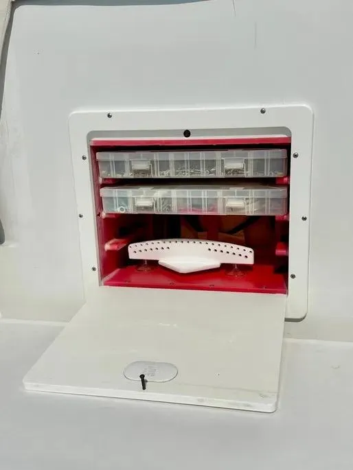 Slide: The Image of Storage compartment on a 2008 Buddy Cannady 28 Custom Express boat, featuring organized tackle boxes. - 27