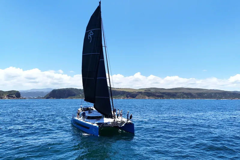 Slide: The Image of Sleek 2026 Knysna 550 catamaran sailing on blue ocean under clear sky. - 8