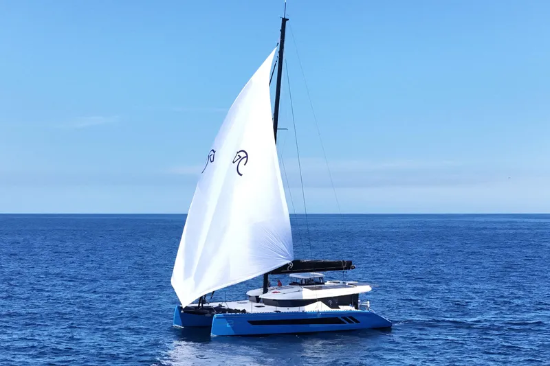Slide: The Image of Sleek 2026 Knysna 550 catamaran sailing on open ocean under clear blue sky. - 9
