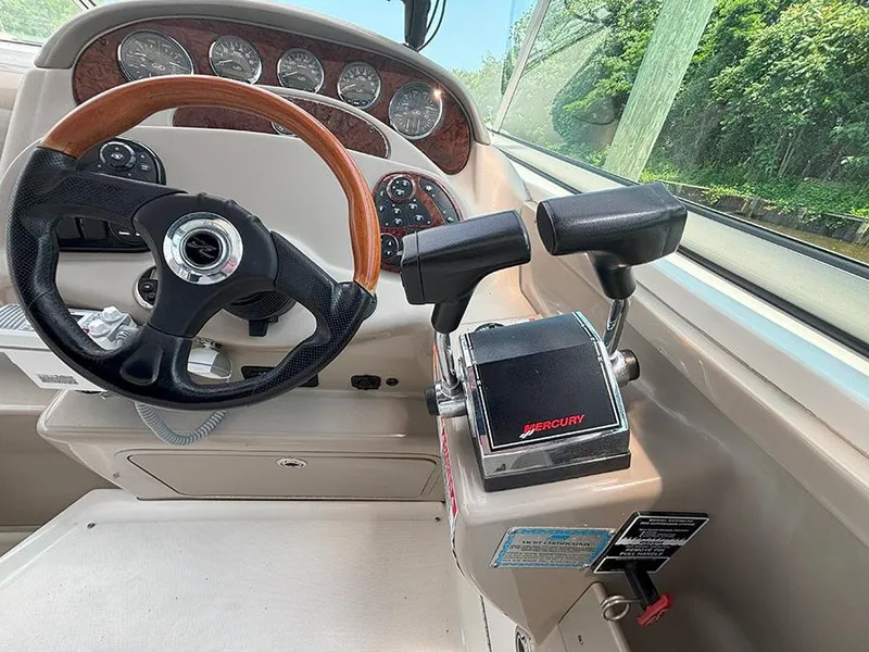 Slide: The Image of 2007 Sea Ray 280 Sundancer helm with steering wheel and Mercury throttle controls. - 10