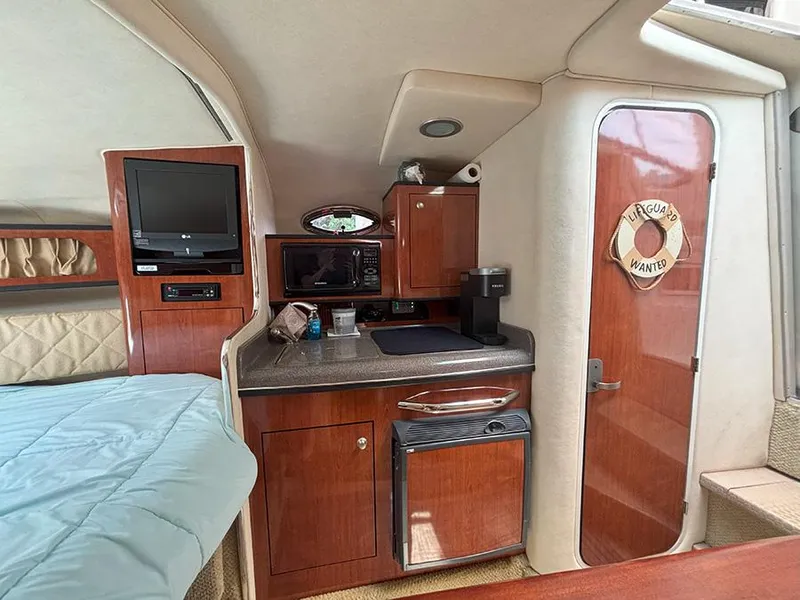 Slide: The Image of Interior of 2007 Sea Ray 280 Sundancer with kitchenette, TV, and cozy sleeping area. - 14