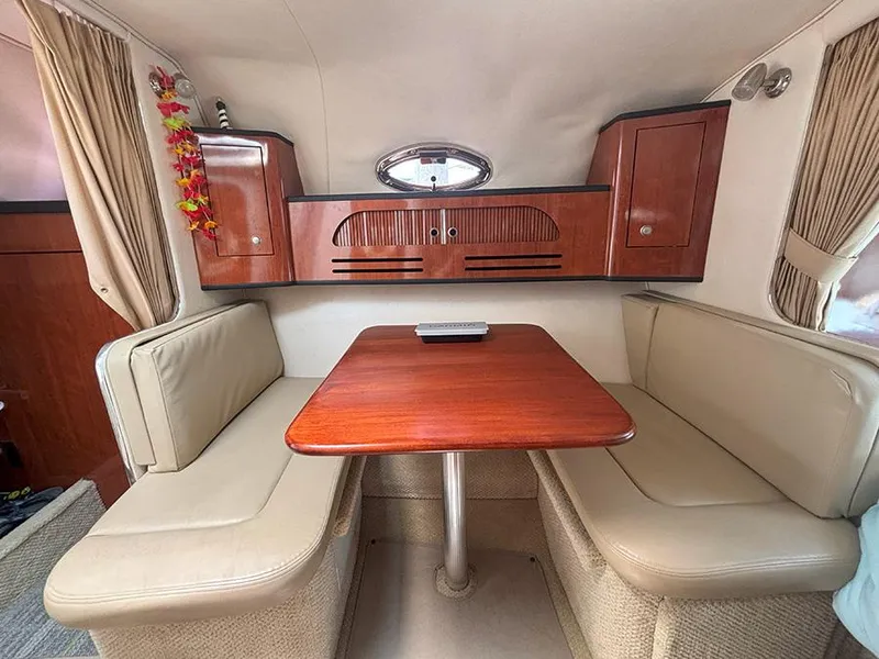 Slide: The Image of Interior of 2007 Sea Ray 280 Sundancer with wooden table and beige seating. - 15
