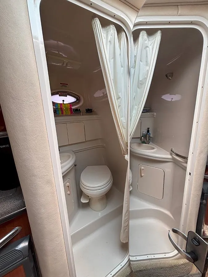 Slide: The Image of Compact bathroom in 2007 Sea Ray 280 Sundancer boat, featuring toilet and sink. - 18