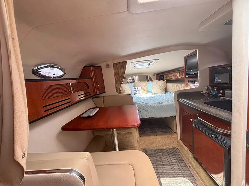 Slide: The Image of Interior of 2007 Sea Ray 280 Sundancer, featuring cozy cabin with dining area and kitchenette. - 19