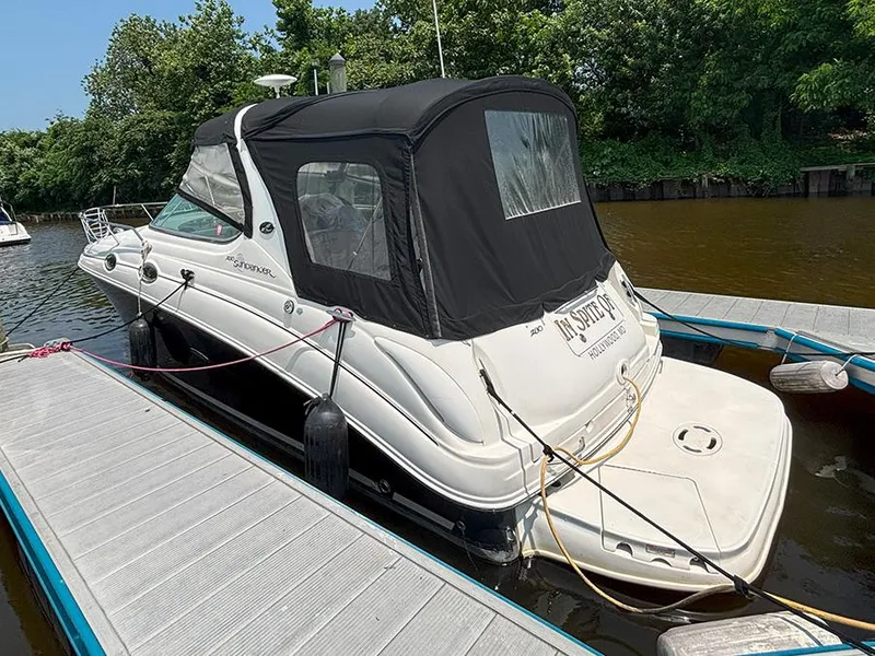 Slide: The Image of 2007 Sea Ray 280 Sundancer docked, featuring black canopy and sleek design. - 2