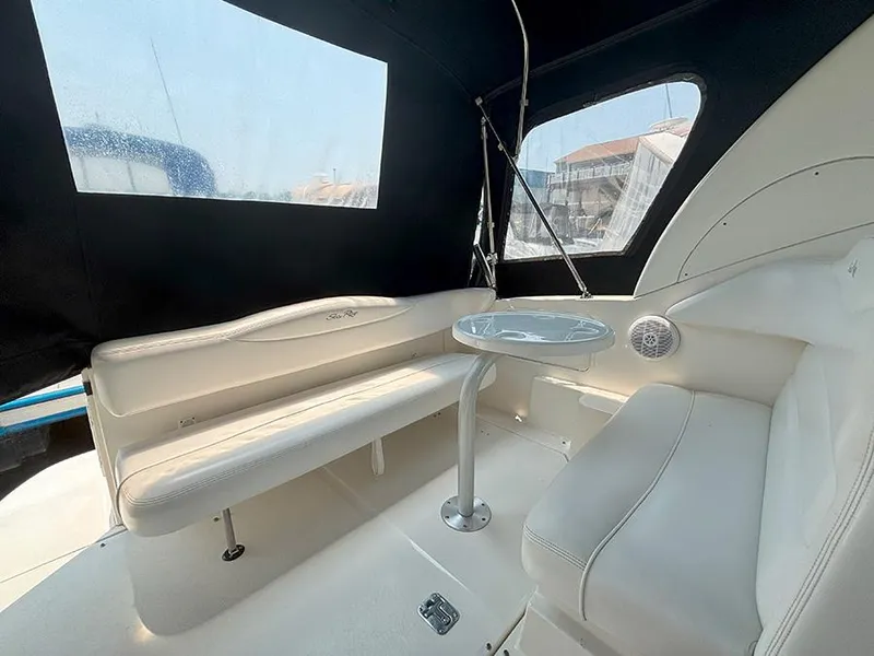 Slide: The Image of 2007 Sea Ray 280 Sundancer interior with white seating and table, enclosed by black canopy. - 3