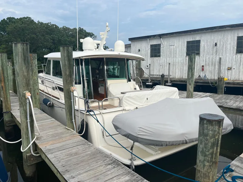 Slide: The Image of 2021 Sabre 48 Salon Express yacht docked at marina with covered dinghy. - 3