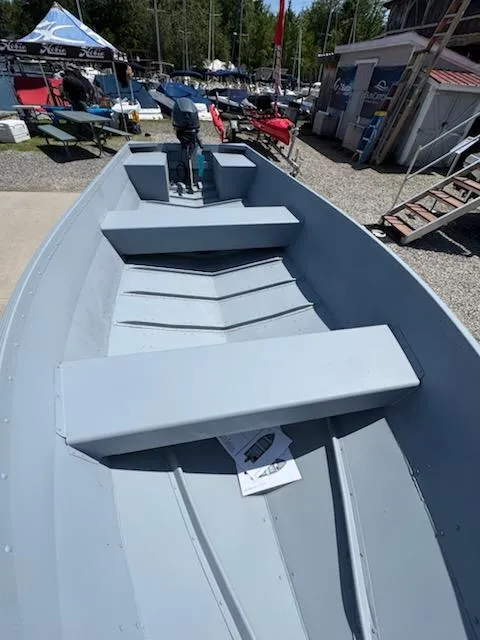 Slide: The Image of 2025 G3 Guide V16 XT boat interior at outdoor display, featuring seating and motor. - 2