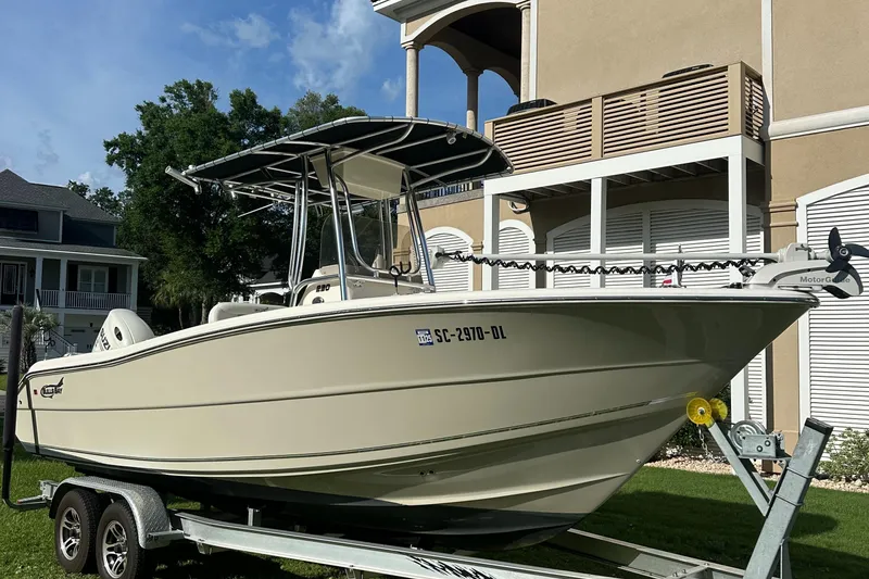 Slide: The Image of 2019 Bulls Bay 230 Center Console boat on trailer, parked near a house. - 5