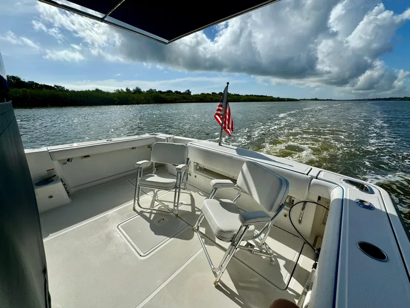Slide: The Image of 2006 Tiara Yachts 3200 Open cruising with chairs and American flag on deck. - 14